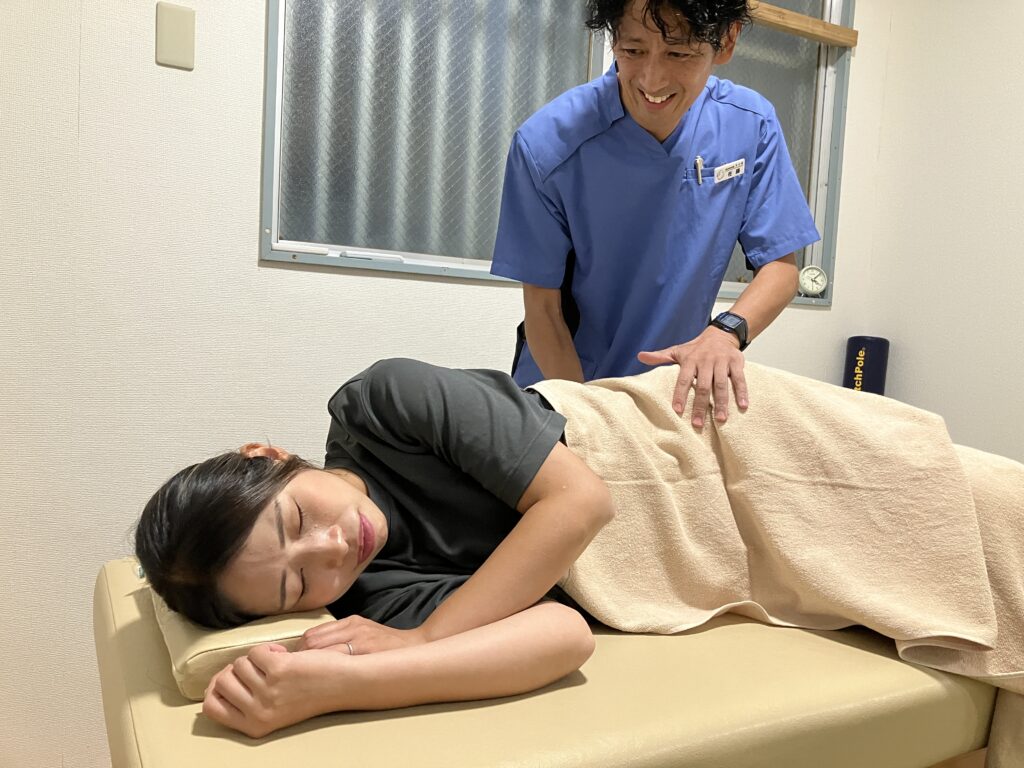 腰痛のお客様に対してやさしい整体を行う院長の佐藤