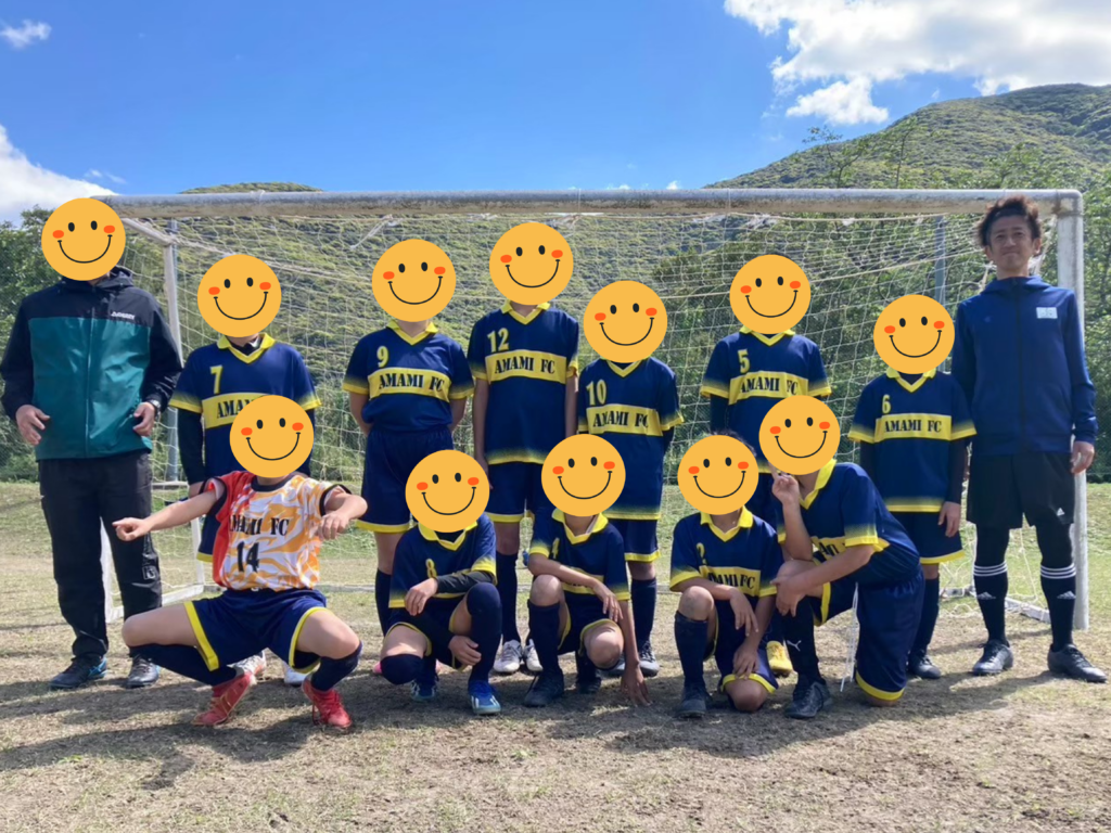 奄美小学校サッカースポーツ少年団のゴール前集合写真・佐藤監督と子どもたち