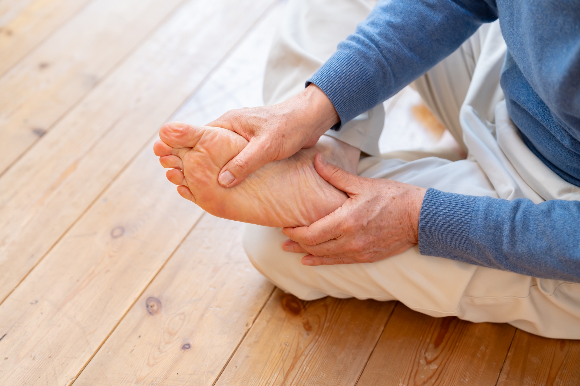 魚の目やタコ、足の裏の疲れや靴擦れなどに悩んでいる男性のイメージ写真