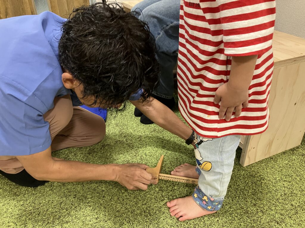 お子さまの足の計測風景の画像