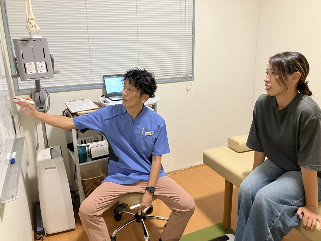 骨格模型を使って肩こりの原因を説明するBALANCECARE 接骨院 らくだの佐藤代表