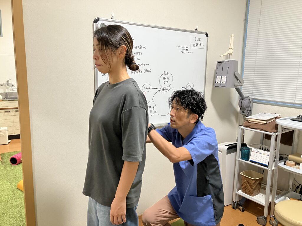 首と肩まわりの姿勢を横から検査するBALANCECARE 接骨院 らくだの佐藤代表