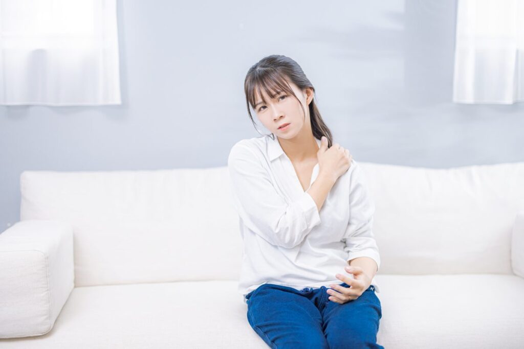 肩に手を当てる女性のイメージ